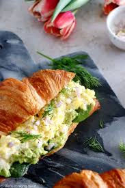 Oufs brouillés au jambon de dinde et au fromage servi à l'intérieur d'un croissant